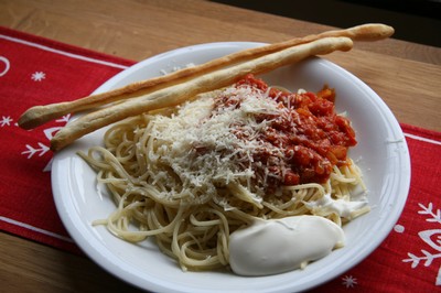 Torgnys tomatsås med spagetti, en klick crème fraiche, grissini och riven parmesanost.